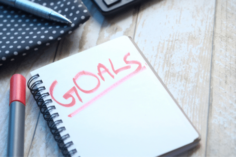 Notebook with big red letters that spell the word goals.