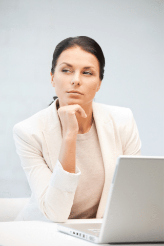 Woman sitting in front of a laptop considering taking over the family business