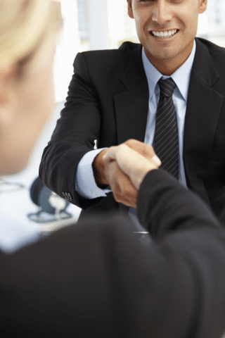 closeup picture of a handshake in business suits